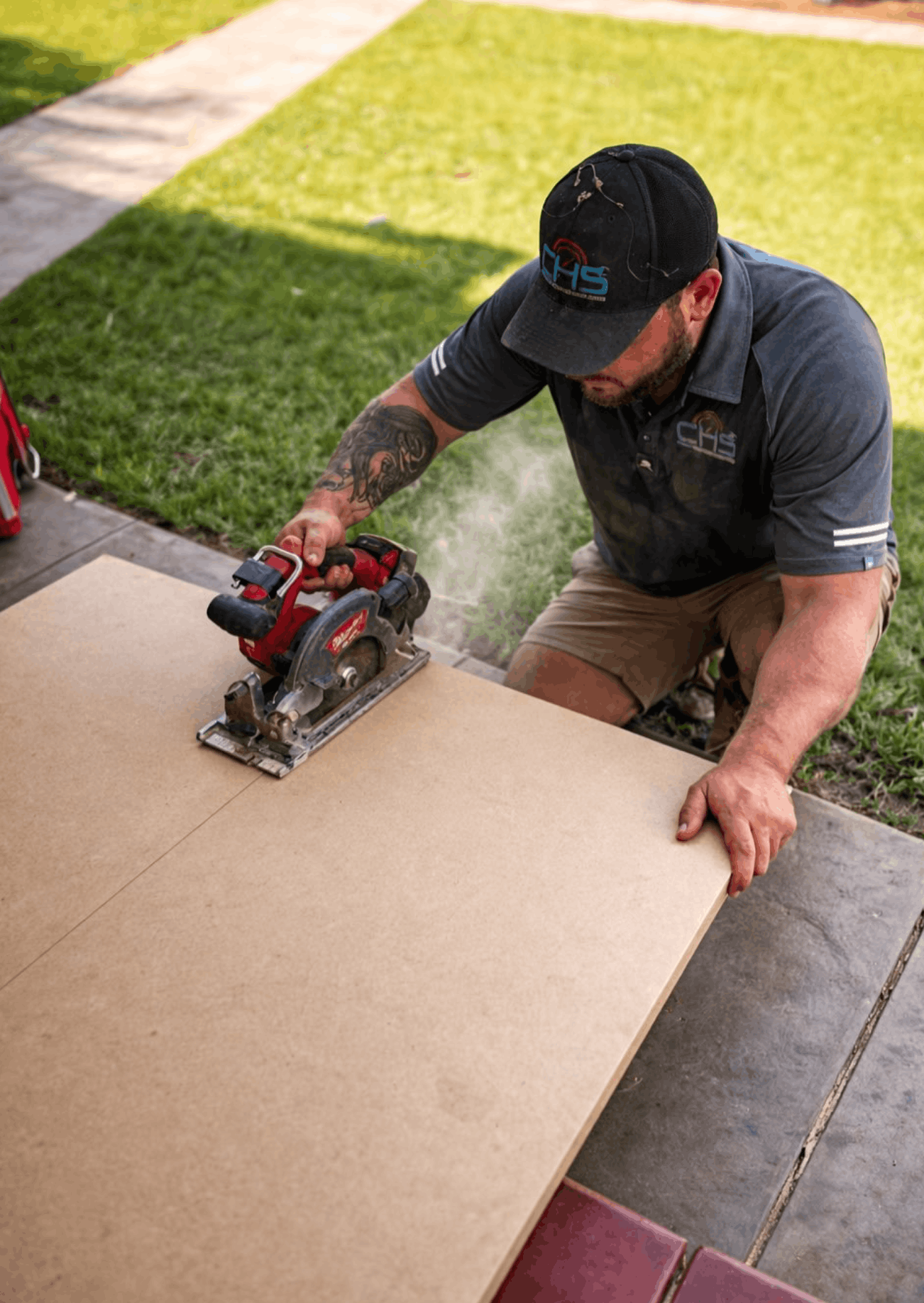 Chad from CHS cutting materials on a Broken Hill air conditioning install